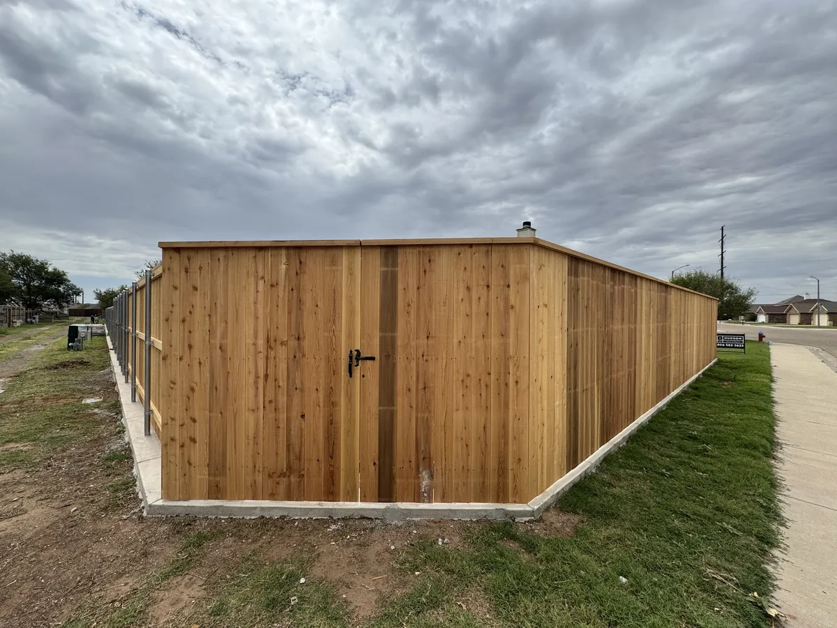 7 ft capped cedar privacy fence with a walk gate, built on steel posts by Hudson Fence Company in Lubbock, TX