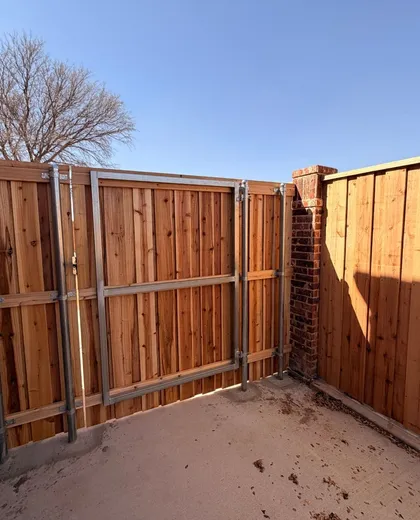 Steel gate frame on a capped cedar fence gate inside a concrete courtyard
