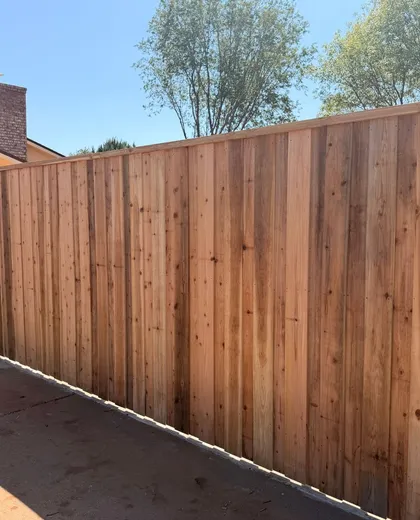 New capped cedar board-on-board fence along a driveway