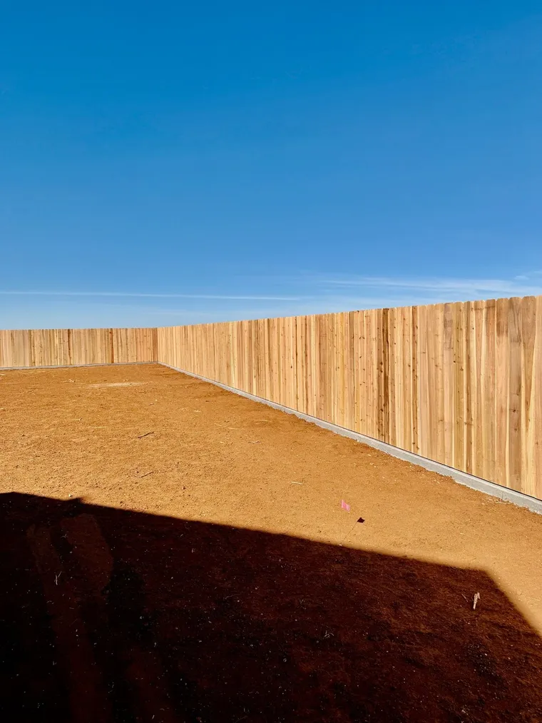 6 ft dog ear cedar fence on a concrete curb around a new-build backyard in Lubbock, TX