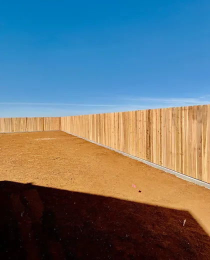 6 ft dog ear cedar fence on a concrete curb around a new-build backyard in Lubbock, TX