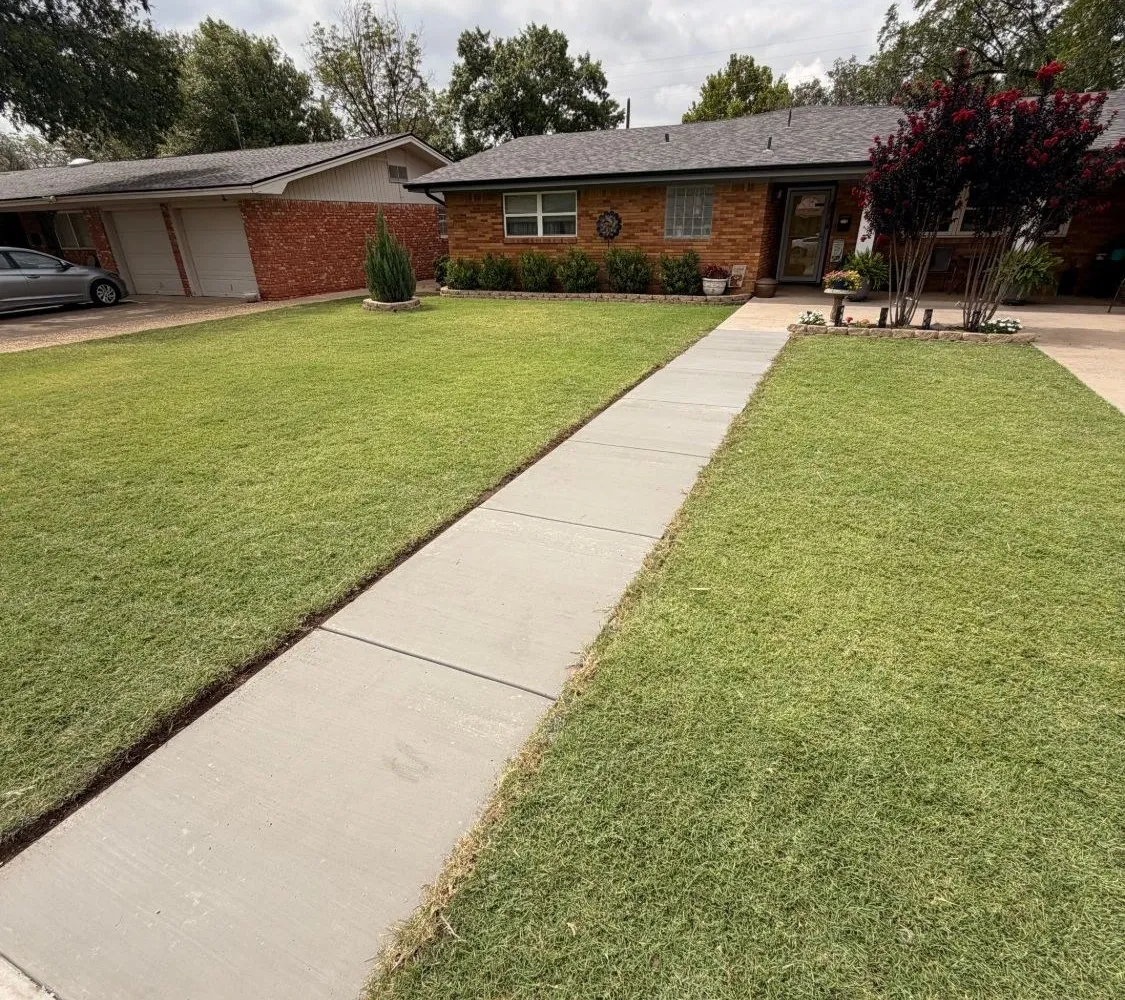 New concrete front sidewalk poured by Hudson Fence Company at a brick home in Lubbock, TX