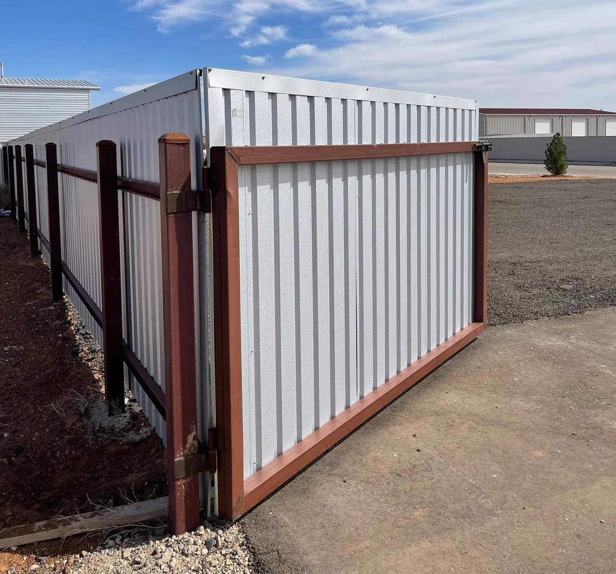 R-Panel steel privacy fence with a steel-framed drive gate built by Hudson Fence Company in Lubbock, TX