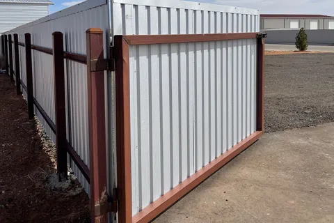 R-Panel steel privacy fence with a steel-framed drive gate installed by Hudson Fence Company in Lubbock, TX