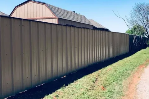 Tan R-Panel steel privacy fence installed by Hudson Fence Company in Lubbock, TX